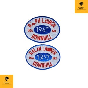 May include: Two oval-shaped embroidered patches with a blue border and white background. Each patch features the text "RALPH LAUREN 1967 DOWNHILL SKI" in red and white. The word "USA" is also included on each patch.