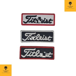 Peut inclure: Trois écussons brodés avec le mot "Titleist" en écriture cursive. Les écussons sont rectangulaires avec des fonds blancs, noirs et rouges. Ces écussons sont destinés aux amateurs de golf.