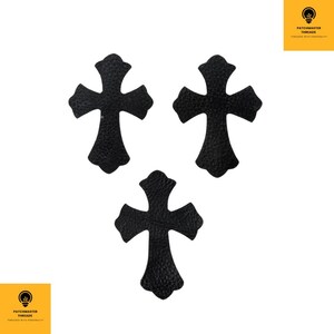 Peut inclure: Trois écussons noirs en forme de croix avec un aspect texturé semblable au cuir sont disposés sur un fond blanc. Les écussons ont des bords arrondis et un design de croix classique. Le logo "PATCHMASTER THREADS" est dans les coins supérieurs et inférieurs.