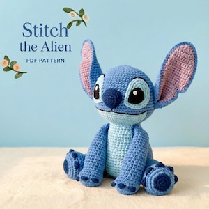 May include: A handmade blue crochet Stitch doll with large ears, black eyes, and a dark blue nose. The doll is sitting with its legs extended. The text "Stitch the Alien PDF Pattern" is visible in the image.