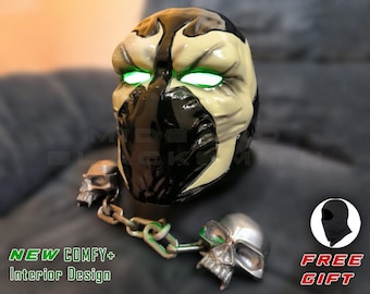Op de afbeelding: Een Spawn-masker met gloeiende groene ogen, zwart-wit ontwerp en een ketting met schedelaccenten. Het masker heeft de tekst "NEW COMFY+ Interior Design" in het groen. Een gratis cadeau is inbegrepen.