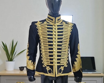 May include: Black military-style jacket with gold embroidery. The jacket features a high collar and ornate gold detailing on the front, sleeves, and shoulders. The jacket is displayed on a black mannequin.
