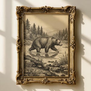 May include: An antique-style framed print featuring a detailed illustration of a bear wading through a river. The artwork is in black and white, set against a backdrop of a forest and mountains. The ornate gold frame adds a vintage aesthetic.