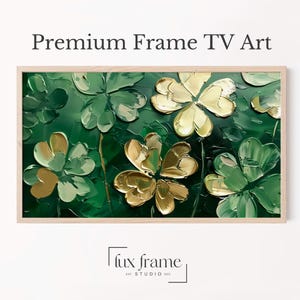 May include: A framed artwork featuring a textured, close-up view of shamrock-like flowers in shades of green and gold. The words "Premium Frame TV Art" are at the top. The artwork is in a light-colored wooden frame.