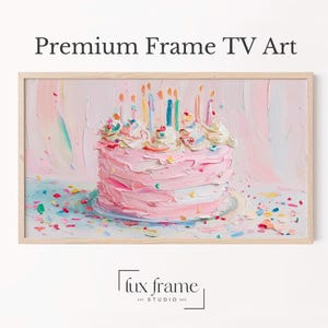 May include: A framed digital art print of a birthday cake with pink frosting, colorful sprinkles, and lit candles. The artwork is displayed in a light-colored wooden frame. The text "Premium Frame TV Art" is at the top.