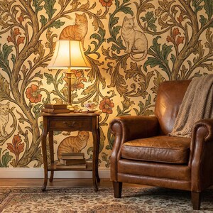 Pode incluir: Uma cena interior acolhedora com uma poltrona de couro castanho e um papel de parede com gatos e desenhos florais em tons de dourado, verde e laranja. Uma pequena mesa de cabeceira de madeira com uma l&acirc;mpada e livros est&aacute; posicionada ao lado da poltrona. Uma manta bege est&aacute; sobre a cadeira.