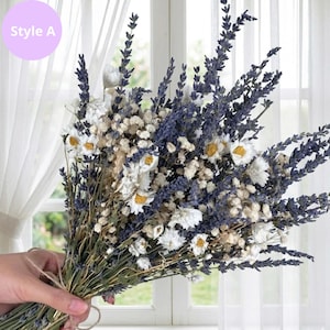 Op de afbeelding: Een boeket van gedroogde bloemen met lavendel, witte madeliefjes en gipskruid, samengebonden met touw. De tekst "Style A" staat in een lichtpaarse cirkel. De bloemen staan voor een raam.