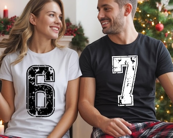 May include: A woman and a man wearing matching t-shirts with the numbers 6 and 7 in a distressed, black and white design. The woman's shirt is white, and the man's is black. They are smiling at each other.