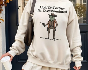 Hold On Partner I'm Overstimulated Sweatshirt, Cowboy Frog Unhinged Hoodie, Funny Frog Meme Sweater, Western Frog Graphic Shirt.