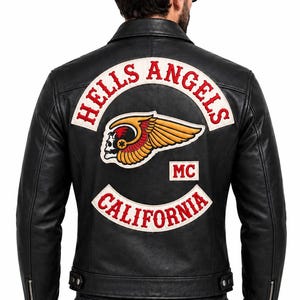 May include: A black leather jacket featuring a large embroidered patch on the back. The patch displays the text HELLS ANGELS in red, a winged skull graphic, the letters MC in a white box, and the word CALIFORNIA in red on a curved white banner.