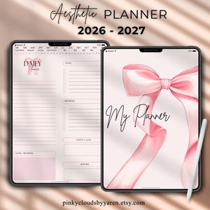 May include: Two digital tablets displaying a 2026-2027 daily planner. One screen shows a daily schedule with sections for to-do lists, priorities, and goals. The other screen features a large pink ribbon graphic and the text My Planner. A white stylus is included.
