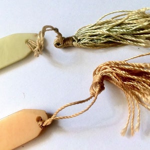 ABRECARTAS DE CELULOIDE FRANCESES DE LA DÉCADA DE 1920 PARA MUJERES ~Juego de 2~ Borlas de celuloide y seda en tonos pastel - Recuerdo de playa/costa de Pornichet ~ Vintage sin usar