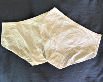May include: Two white lace trimmed underwear with a delicate floral pattern.