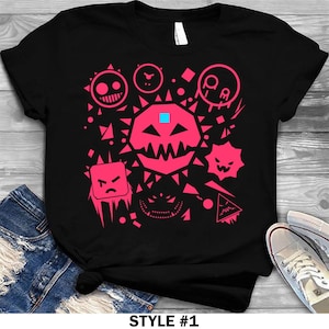 May include: Black t-shirt with a pink geometric design. The design features various shapes and faces, including a central shape with sharp teeth and a blue square. The text "STYLE #1" is at the bottom of the image.