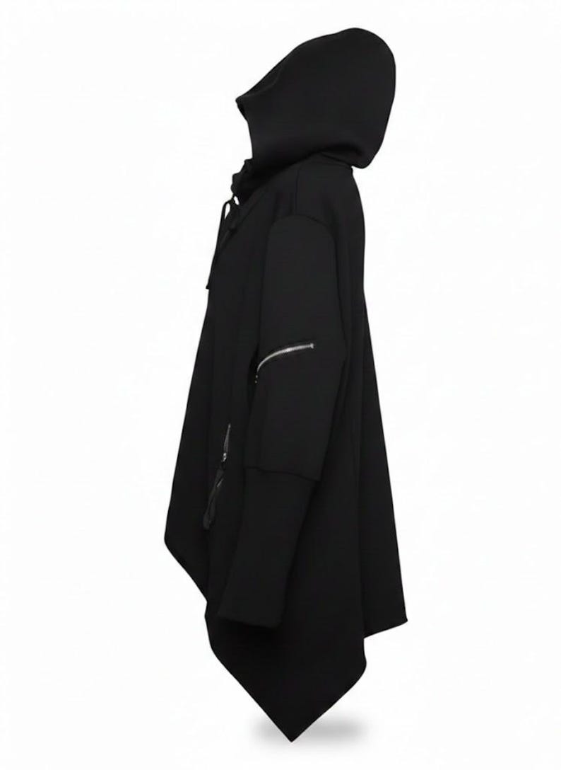 K&ouml;nnte beinhalten: Schwarzer Kapuzenponcho mit einzigartigem asymmetrischem Design. Mit gro&szlig;er Kapuze, langen &Auml;rmeln mit Rei&szlig;verschlussakzenten und einer drapierten, flie&szlig;enden Silhouette. Ein modernes, kantiges Oberbekleidungsst&uuml;ck.
