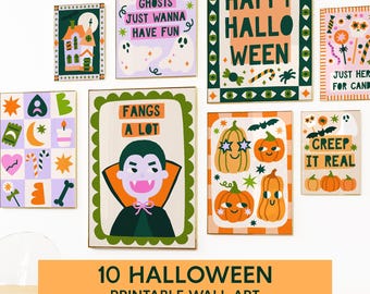 May include: A collection of ten Halloween-themed printable wall art pieces. The art features colorful illustrations of pumpkins, ghosts, a vampire, and the phrases "Happy Halloween", "Creep It Real", and "Fangs A Lot". The art is displayed on a white wall.
