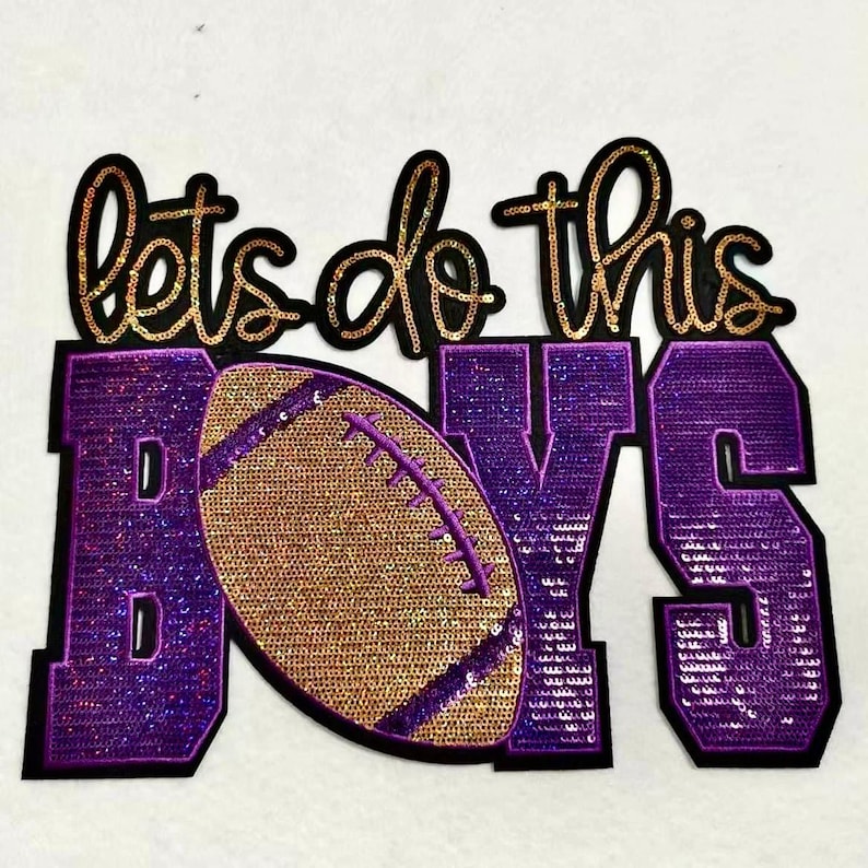 May include: A sequined patch with the words "lets do this" in gold and black script above the word "BOYS" in purple. A gold football with purple stitching is in the center. The patch is likely for apparel.