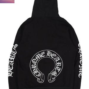 May include: Black hooded sweatshirt featuring white lettering on the sleeves and a large white graphic on the back. The graphic reads "Chrome Hearts" in a circular design. The brand name "Top Ten Threads" is in the upper left corner.
