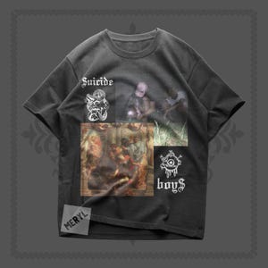 Puede incluir: Camiseta gris oscuro con varios diseños gráficos. La camiseta presenta la palabra "Suicide" en blanco, junto con otras imágenes y la palabra "boy$". Una pequeña etiqueta "MERYL" es visible.