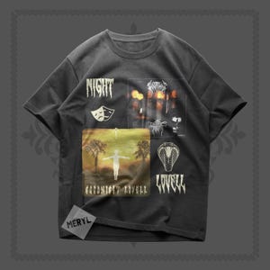 Puede incluir: Camiseta gris oscuro con múltiples diseños gráficos. La camiseta presenta las palabras "NIGHT" y "LOVELL" en blanco, junto con otras imágenes, incluyendo una cobra, una persona con los brazos extendidos y el texto "GOODNIGHT LOVELL".
