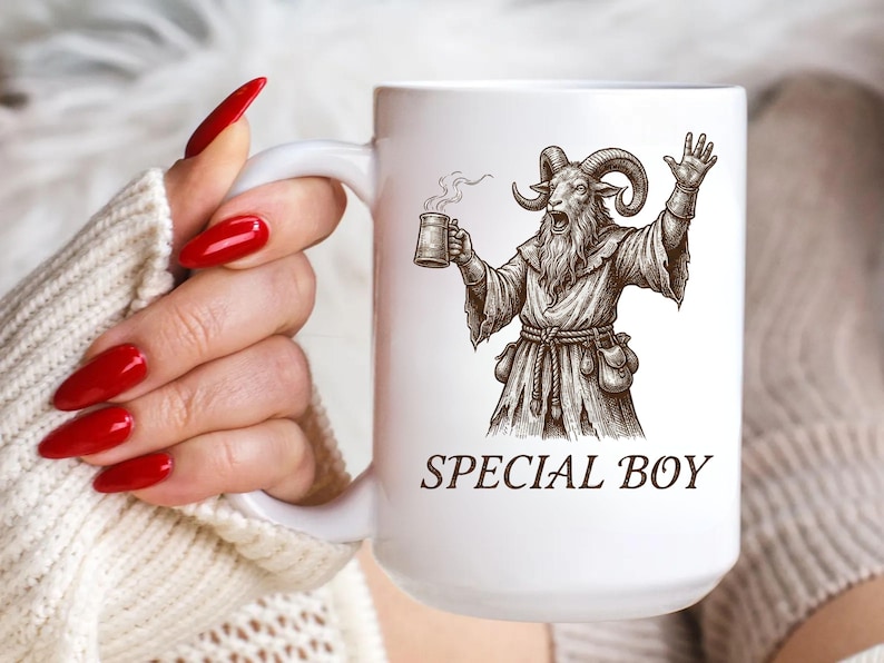 May include: White ceramic mug featuring a detailed illustration of a goat-like figure in robes, holding a mug of ale and raising a hand. The text "SPECIAL BOY" is printed below the illustration. The mug has a large handle.