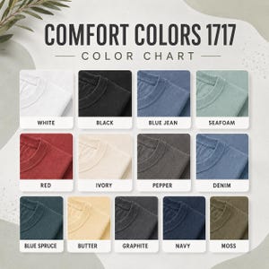 May include: A Comfort Colors 1717 color chart displaying twelve fabric swatches in white, black, blue jean, seafoam, red, ivory, pepper, denim, blue spruce, butter, graphite, navy, and moss, each labeled with its corresponding color name.