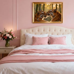 Puede incluir: Un dormitorio con un cuadro enmarcado de dos tigres. La cama tiene un edredón blanco, almohadas rosas y una manta rosa. Un ramo de flores está sobre una mesita de noche. Las paredes están pintadas de rosa.