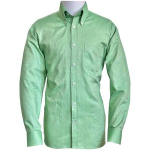 Puede incluir: Camisa verde claro con botones, cuello abotonado y bolsillo en el pecho. La camisa de manga larga tiene botones y puños blancos. La camisa está hecha de una tela texturizada.