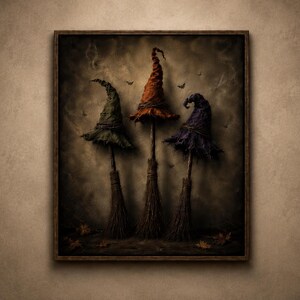 May include: A framed wall art print featuring three witch hats in green, orange, and purple, each perched atop a broomstick. The scene is set against a dark, smoky background with small flying bats and scattered autumn leaves on the ground.