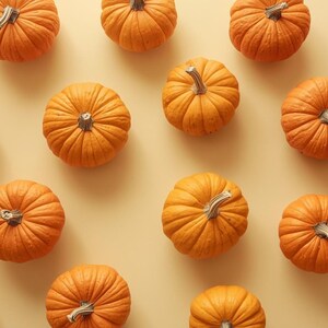 Puede incluir: Vista a&eacute;rea de un patr&oacute;n de peque&ntilde;as calabazas naranjas con superficies texturizadas y tallos verde-marrones. Las calabazas est&aacute;n dispuestas sobre un fondo amarillo claro, creando un tema oto&ntilde;al.