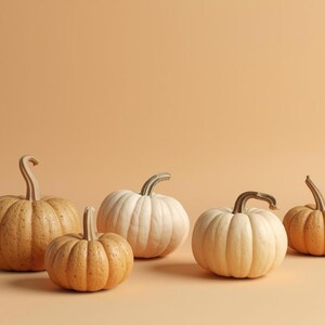 Puede incluir: Cinco calabazas de varios tama&ntilde;os y tonos naranja y blanco sobre un fondo melocot&oacute;n liso. Las calabazas, con superficies texturizadas y tallos curvos, evocan el tema de la cosecha de oto&ntilde;o.