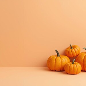Puede incluir: Cuatro calabazas naranjas de diferentes tama&ntilde;os se colocan contra un fondo color melocot&oacute;n. Las calabazas tienen tallos verdes y superficies texturizadas, lo que evoca un tema oto&ntilde;al. Las calabazas son de color naranja brillante.