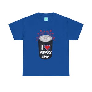 Könnte beinhalten: Königsblaues T-Shirt mit einem Aufdruck einer Pepsi Zero Dose, einem roten Herz und den Worten "I Pepsi Zero". Das Design beinhaltet rote Sternschnuppen. Ein lässiges Kleidungsstück.