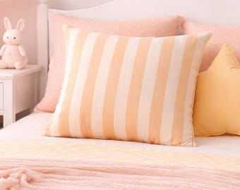 Funda de almohada de lona suave con rayas color crema y melocotón pastel. Decoración neutra para sala de estar o casa de playa. Pieza decorativa ideal para el dormitorio infantil de verano.