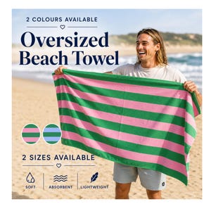 May include: Oversized beach towel with horizontal stripes in pink and green. The towel is held up by a person on a sandy beach. The text on the image says "2 colours available", "Oversized Beach Towel", "2 sizes available", and "Soft, Absorbent, Lightweight".