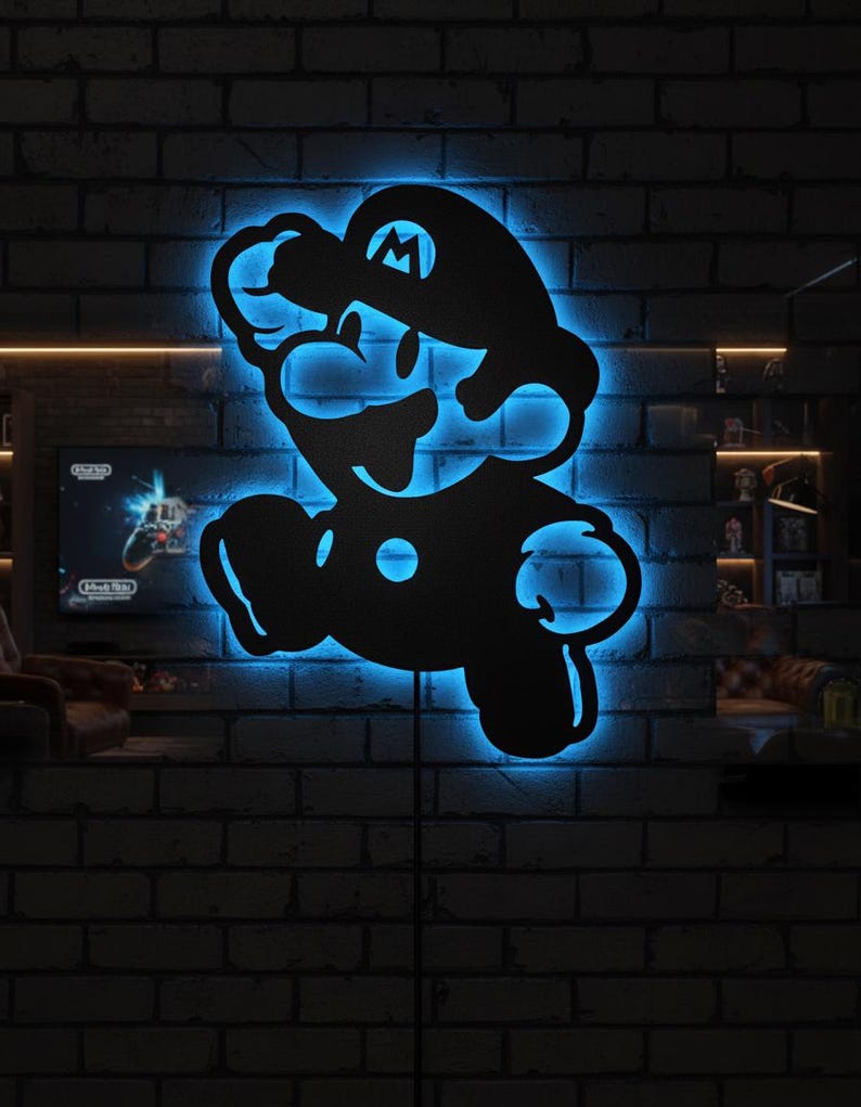 K&ouml;nnte beinhalten: Schwarze Metall-Wandkunst mit der Silhouette von Mario mit blauer LED-Hintergrundbeleuchtung. Das Kunstwerk ist an einer dunklen Backsteinmauer angebracht und erzeugt einen auff&auml;lligen Kontrast. Die ikonische Figur ist in einer klassischen Pose dargestellt.