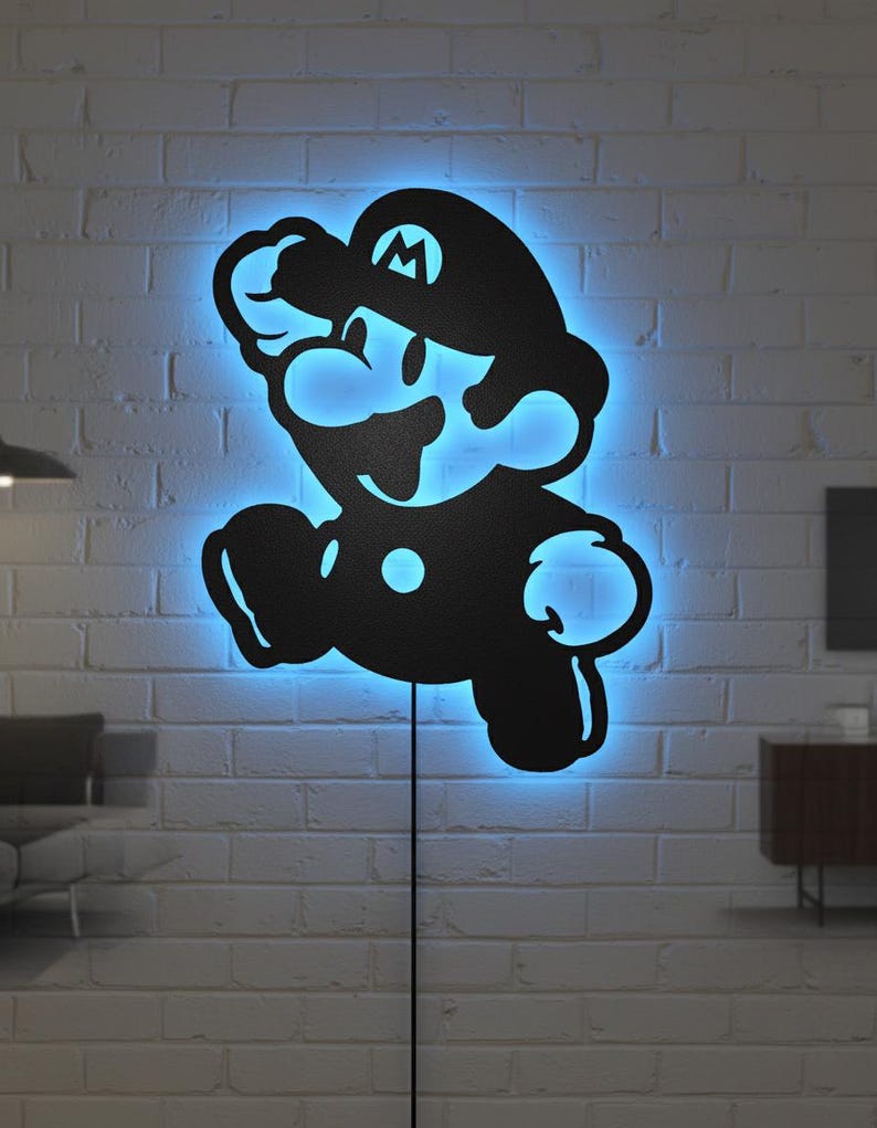 K&ouml;nnte beinhalten: Schwarze Silhouette der Videospiel-Figur Mario, beleuchtet von einem blauen LED-Licht. Das Licht ist an einer wei&szlig;en Backsteinmauer befestigt, mit einem Netzkabel, das nach unten verl&auml;uft.