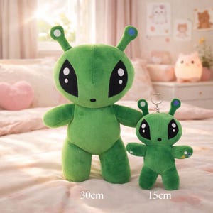 May include: Two green plush alien toys. The larger one is 30cm tall, and the smaller one is 15cm tall. Both have large black eyes, small antennae with white and blue tips, and are standing on a patterned surface.