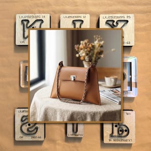 Peut inclure: Un sac à main en cuir marron clair avec une bandoulière et un fermoir en chaîne argentée. Le sac est rectangulaire avec une forme trapézoïdale. Des blocs de bois avec des motifs de chaînes métalliques et du texte entourent le sac.