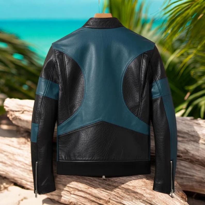 May include: Black and teal leather jacket with a classic design. The jacket features teal panels on the back and sleeves, with black accents and a zipper closure. The jacket is hanging on a wooden hanger.