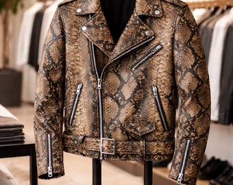 May include: A brown and black snakeskin-patterned leather motorcycle jacket featuring silver-toned metal zippers on the front, chest, and cuffs, a notched lapel collar, shoulder epaulets, and a buckled belt at the waist.