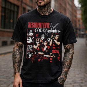 May include: Black t-shirt featuring the text "RESIDENT EVIL - CODE: Veronica" in red and white. The shirt has a graphic of characters from the video game in red and white.
