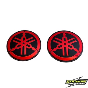 Peut inclure: Deux autocollants ronds avec le logo Yamaha, noirs et rouges. Le logo Yamaha est rouge sur fond noir. Les autocollants sont sur fond blanc. Le texte "STICKERS WHITE" est en bas.