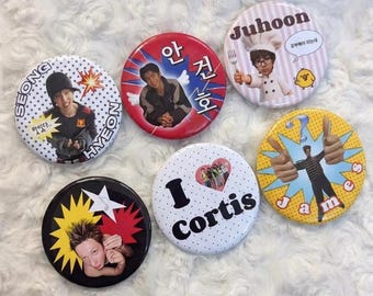 May include: Five circular pin-back buttons featuring various designs: one with a person and text "SEONG HYEON", one with a person and Korean text, one with a chef and "Juhoon", one with a person and "I Cortis", and one with a person and "James".