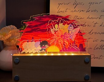 May include: A rectangular wooden base with four silver circular accents supports a clear acrylic panel featuring a vibrant pixel art scene. The design displays a character wielding a sword against a sunset background with red, orange, and yellow hues.