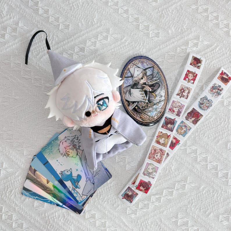 May include: A plush doll with white hair and a gray hat, a circular pin featuring an illustrated character, a stack of holographic cards with anime-style art, and two vertical strips of small square stickers depicting various colorful character portraits.