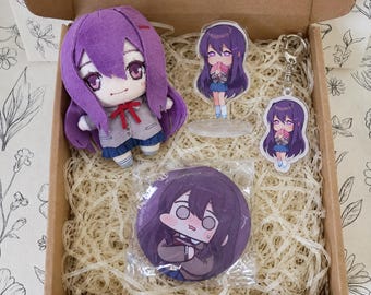 May include: A gift box containing a purple-haired plush doll, an acrylic character standee, a matching acrylic keychain, and a circular button pin, all featuring a character with long purple hair and a school uniform in a brown cardboard box.