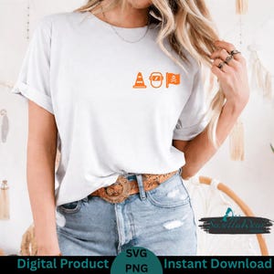 May include: White t-shirt with orange graphic of a traffic cone, welding mask, and pirate flag. The shirt is a digital product available as an SVG and PNG file.