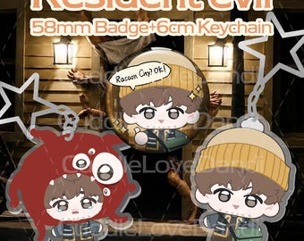 May include: A Resident Evil themed set featuring a 58mm circular badge and a 6cm acrylic keychain. The badge shows a cartoon character in a yellow beanie with the text Racoon City? Ok!. The keychain depicts the same character in a red monster suit.