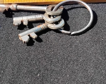 3 clés vintage 2 ressemblent à des clés de cadenas et une clé de porte en état d'usage